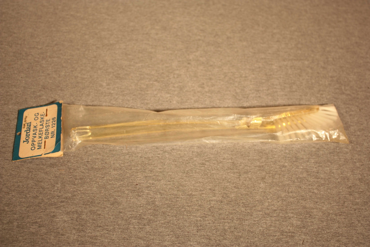 Smal kost med nylonbust og langt skaft i plast. Ligg i original plastpakning.
