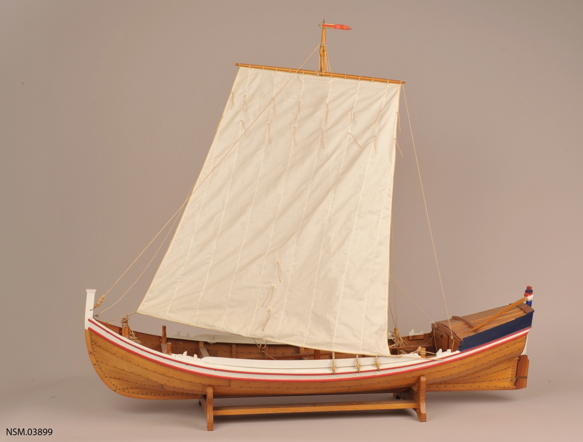 Klinkbygget  modell med løfting og ror, rorkult, 4 årer (NSM.07948-51), mast, tiljer,2 tofter. Rigget med seil. Lakket skrog, øverste bordgang malt hvit med to smalere røde linjer på hver side. Løfting blå sider. Akterspeil hvitt. Ror over vannlinjen hvitt og blått.  Målestokk 1:18.