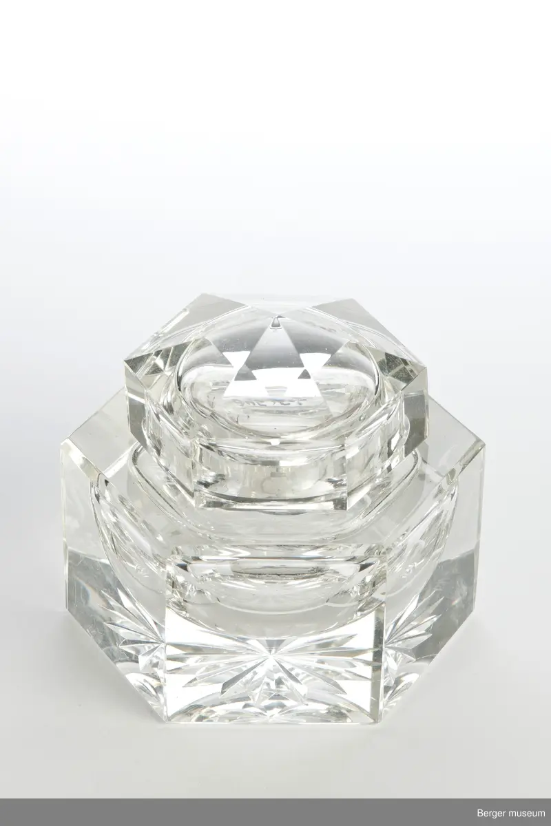 Blekkhus med lokk og en liten beholder til å ha blekk i. Objektet består derfor av tre deler. Stjernemønster under. Blekkhuset og lokket er 6-kantet.