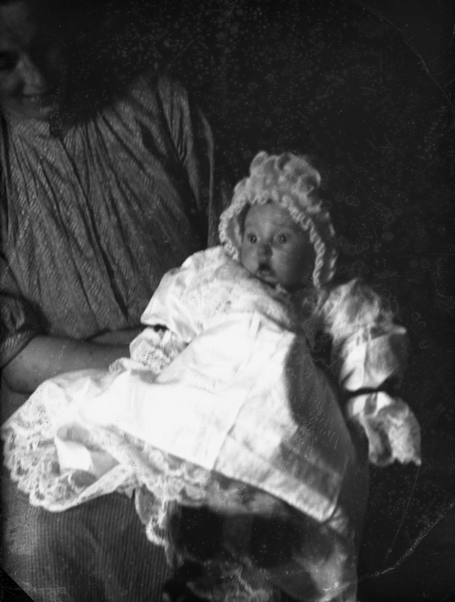 Kvinne med barn på fanget, mørk bakgrunn