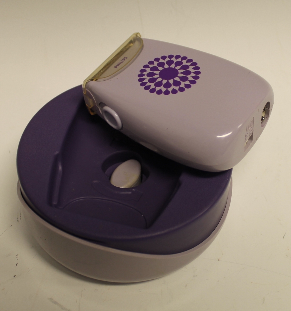 Bargbermaskin med ledning og etui. Etui er i tre deler som passer inni hverandre. Ledning ligger nederst i en hylle for seg.