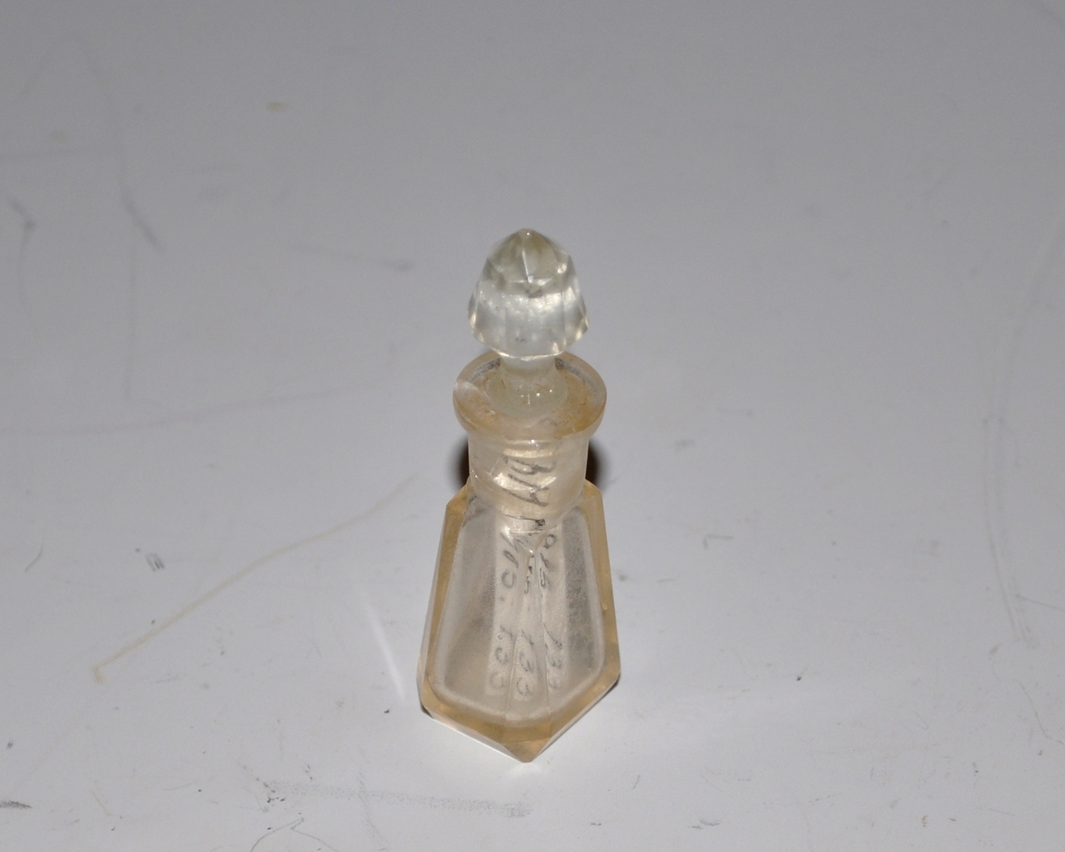 Parfymeflakong med kork. Glass, avflatete kanter, korktopp fasettslipt, som ender i en stift til påføring av parfymen.