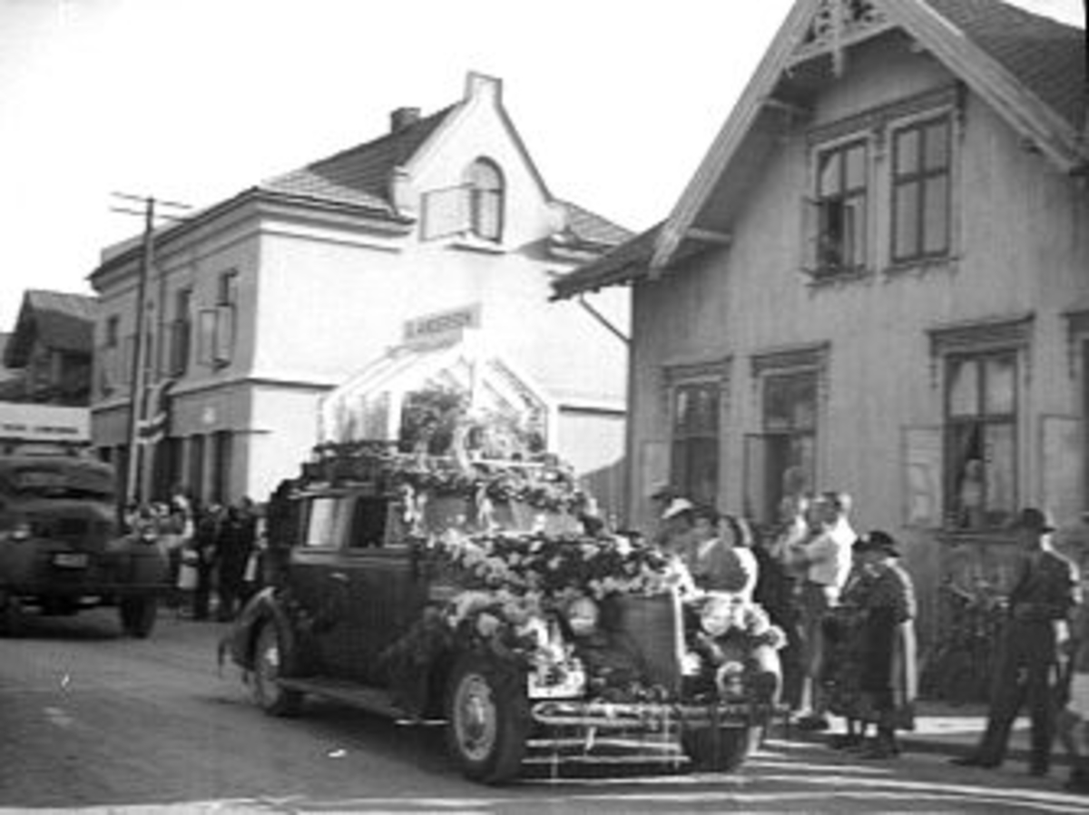 En samling bilder fra Skien, bl.a. Skiensdagene med opptog. Fruktaroma hadde 10-15 mann som gikk i oppdrag med kurver og delte ut vareprøver, samt 1 bilde fra krigen der tyske soldater marsjerer mot brakken på Gjemsø. Fotografiet er tatt fra bakken opp mot Sykekehuset. Borg ble oppdaget og tatt inn til forhør.