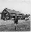 Bäcke, Dalslands Fornminnes- och Hembygdsförbunds årsmöte 1967. Bruksgatan..  Folksamling utanför byggnad. I förgrunden t.f. landsantikvarie Christian Aarsrud.