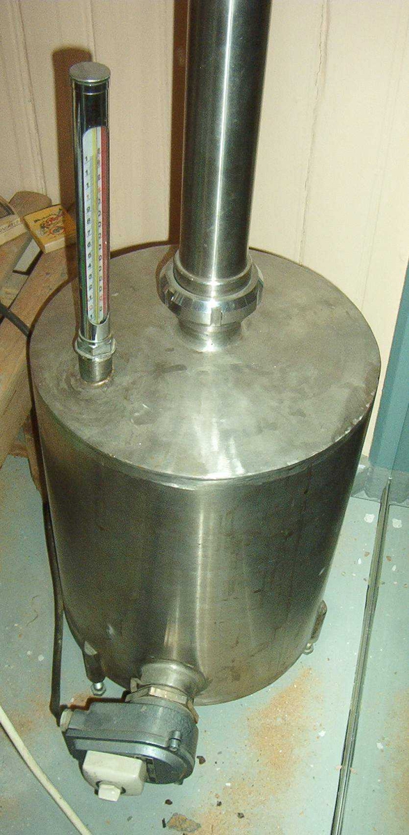 Hjemmebrentsapparat med tårn. Apparatet er 2,10 meter høyt. Det er to gradestokker, en bryter med tre trinn.