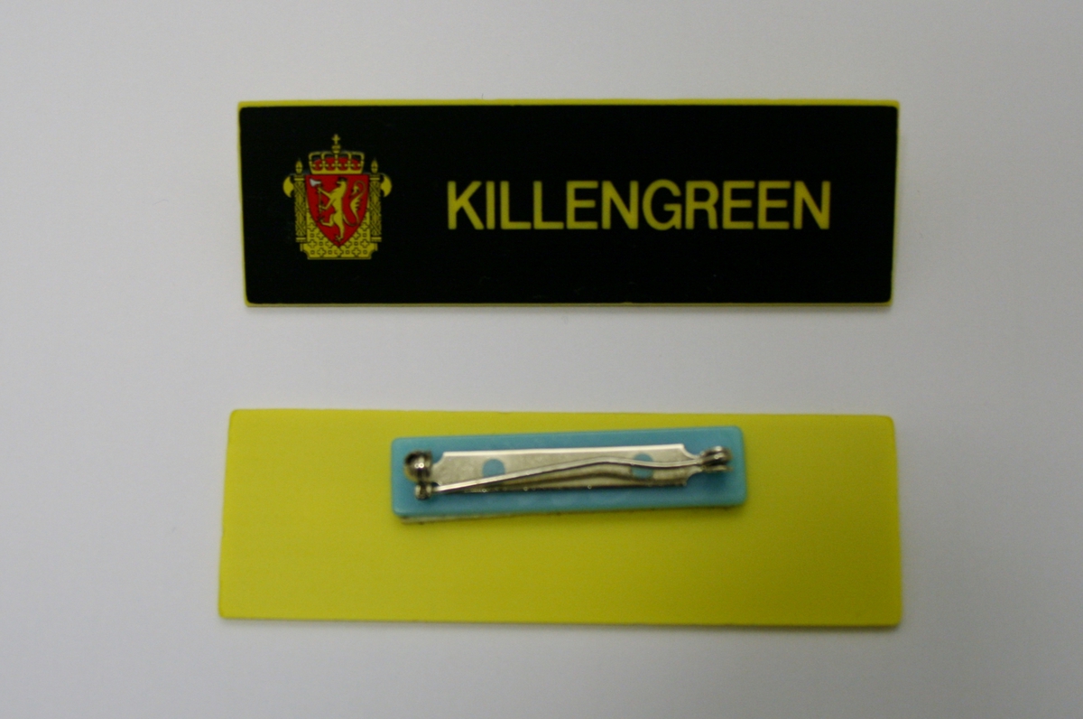 Foret, sort jakke med gullforgylte eikeløvsnåler på kraven. 4 gullforgylte knapper med riksvåpen i front og to ved splitten bak. Epåletter i flettet gull med fire stjerner og eikeløv (politidirektør). Fire lommer med klaff og knapp. Politimerke med riksvåpen på overarmene. Navneskilt i sort plast med gul skrift og riksvåpen. To ekstra navneskilt medfølger.

Knelangt, sort skjørt med glidlås bak.

Et kryssbandolær med gullforgylt rektangulær spenne dekorert med riksvåpen.

Et bredt lærbelte med gullforgylt rektangulær spenne dekorert med riksvåpen.

Et smalt lærbelte med gullforgylt rektangulær spenne dekorert med riksvåpen.

Politilue med hvit pull og luemerke i gull og rødt og eikeløvsbroderier i sort og gull. To forgylte knapper holder luesnoren på plass. (Lue for vinterhalvåret (med sort pull) registrert på NRM.03690)

Slips, skjorte og hvite hansker medfølger ikke.