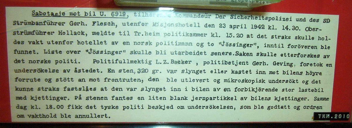 Stein montert i på rød brakgrunn, med tekst og bilder fra åstedet.
