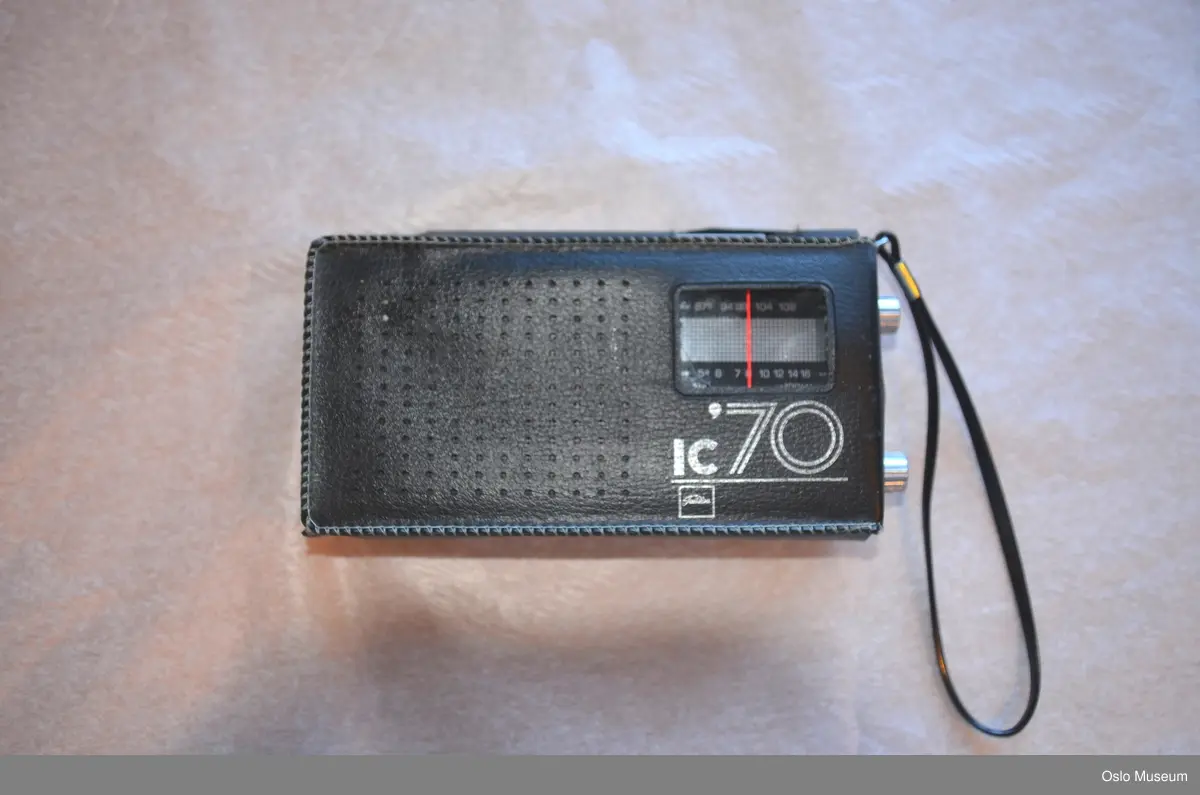 Lommeradio i stål og plast med uttrekkbar antenne. Etui i sort skai med hank.