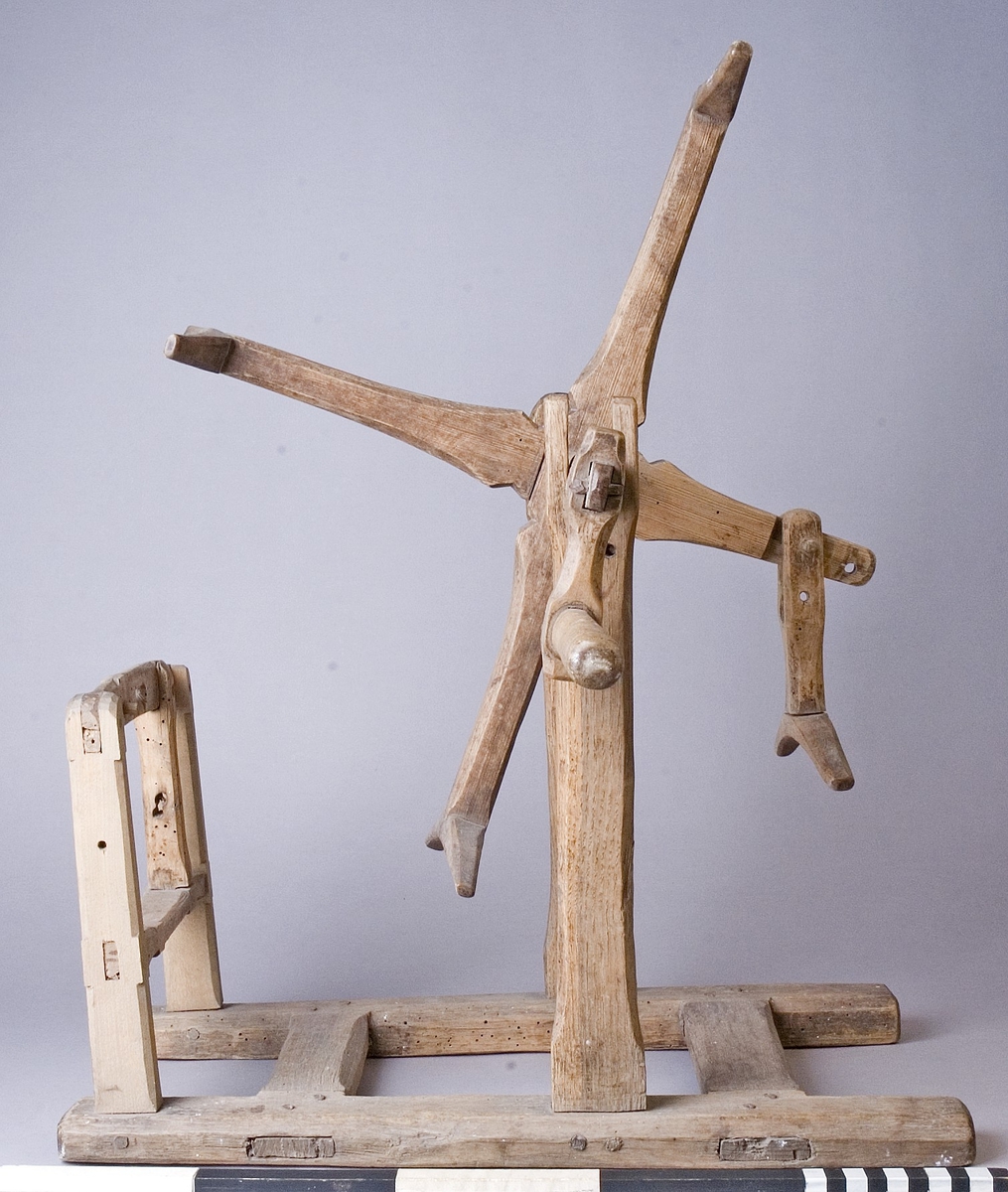 Härvel av furu, ek och björk. Bottenplatta av H-formad ram med två ståndare som bär upp härvelhjulet och två ståndare för hållare till garnspole. Härvelhjulet med fyra armar, varav ett är ledat. Hjulets axel med svarvad vev. Tappad med träplugg.