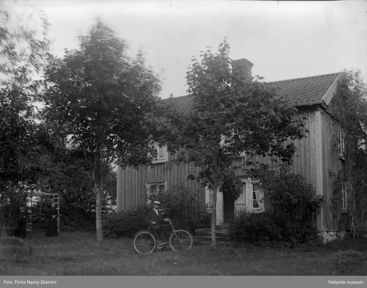 Man med cykel vid hus