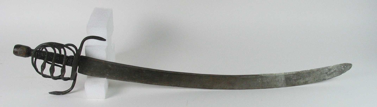 Rund tønneformet knapp i tre. Asymmetrisk feste med tre sidebøyler som har fortykninger på midten på utsiden og tommelbøyle og to sidebøyler på innsiden. Nyreformede parérplater. S-formede runde parérstenger med fortykkede avslutninger på endene. Fremre parérstang er nyere.
Tregrep med jerntrådvikling.
Enegget krum kline med smal ryggstillt blodrand. Smedmerke på venstre side. Klingespissen er dekorert med tre små hull.