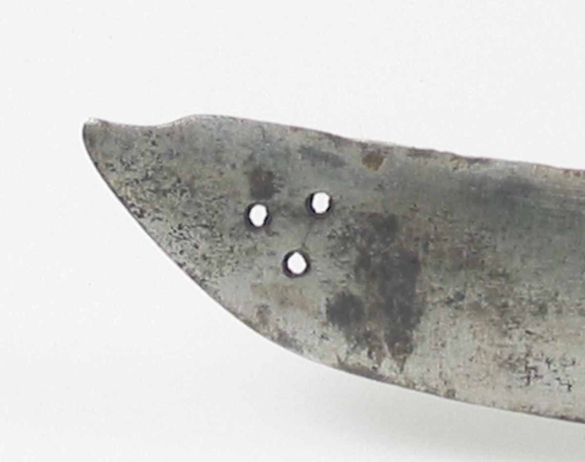 Pyramideformet knapp med strekdekor. Asymmetrisk kurvfeste med to sidebøyler( øverste avbrukket )med riflede fortykkelser på midten. mellom håndbøylen og kurvens ytterkant. Innsiden har en  sidebøyle. Kurvens basis er på utsiden en kvadratisk parérplate med to hjerteformede gjennombrytninger. På innsiden er det en klingebrekker og tommelbøyle. Opp og nedbøyde parérstenger med riflede fortykkelser på endene.
Tregrep med nyere jerntrådvikling.
Enegget krum klinge med 3 hull ipå klingspissen og en smal hulslipning på ryggsiden.Tre smedmerker på venstre side. 