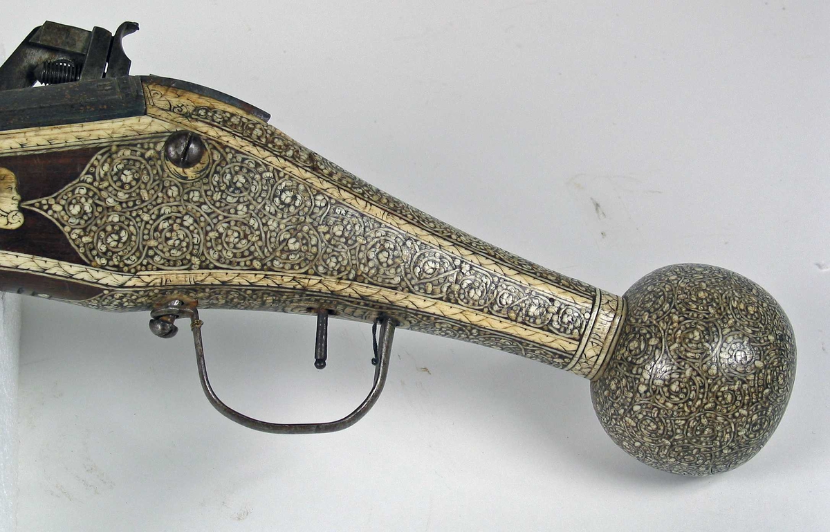 Sivil pistol med hjullås . Flatt låsblikk, tverrskåret i forkant og spisst i bakkant. Låsen er festet til kolben med to gjennomgående skruer.
Rundt glattboret pipe med åttekantet kammerstykke og trompetformet munning. 
Pipen merket med H stående løve og R på kammerstykket.
Avtrekkerbøyle i jern.
Pipen er festet til kolben med to splinter av tre. Kolbe av tre med rikt beninnlegg i forskjellige mønstre.
Ladestokk i tre med horn avstlutning.