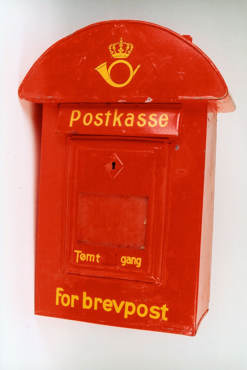 Rød postkasse med gul skrift.