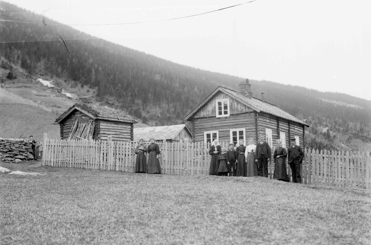 01.06.1909. Gården Dahlen. Bolighus, uthus, gjerde, kvinner, menn, jente, gutt.