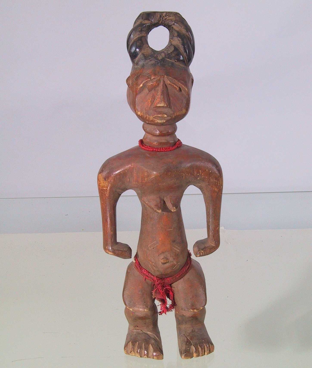 Kvinnefigur, oppsatt hår, bryster, halskjede, lendeklede