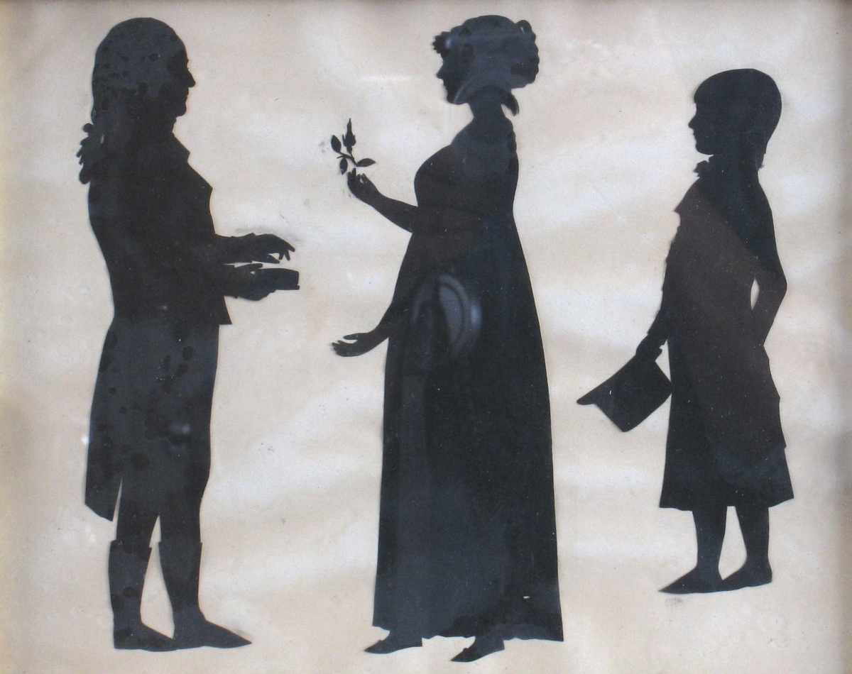 3 personer, stående, helfigur. Silhuett av Peter Andreas Hiorth, 1740 -1817,  (generalmajor, yngste sønn av magister Peder Hiorth og Anna Andersd. Dedekam) med ektefelle (gift 1770)  Birgitte Christine Werner, 1751- 1813, og sønn Peter Andreas Hiorth, 1771 1811, infanterikaptein,  Nannestad.   T.v. general Hiorth prof. h, i piskeparykk, langskjøtet frakk  m. høy krave og brede slag, trange bukser og høye støvler  ("Wertherdrakt"), står m. snusdåse i hånden.  Vendt mot ham, profil v, fru Hiorth, i hånden holder hun  en rosenknopp, iført vid empirekjole m. høyt liv, flate tøysko,  kappe eller høy frisyre på hodet. Helt t. h. m/ profil v.,  sønnen, en halvvoksen gutt: i sid frakk, m. halsbind m. sløyfe, naturlig hår,  børstet frem i pannen, langt i nakken. Holder en  kort, høy stiv hatt i hånden.