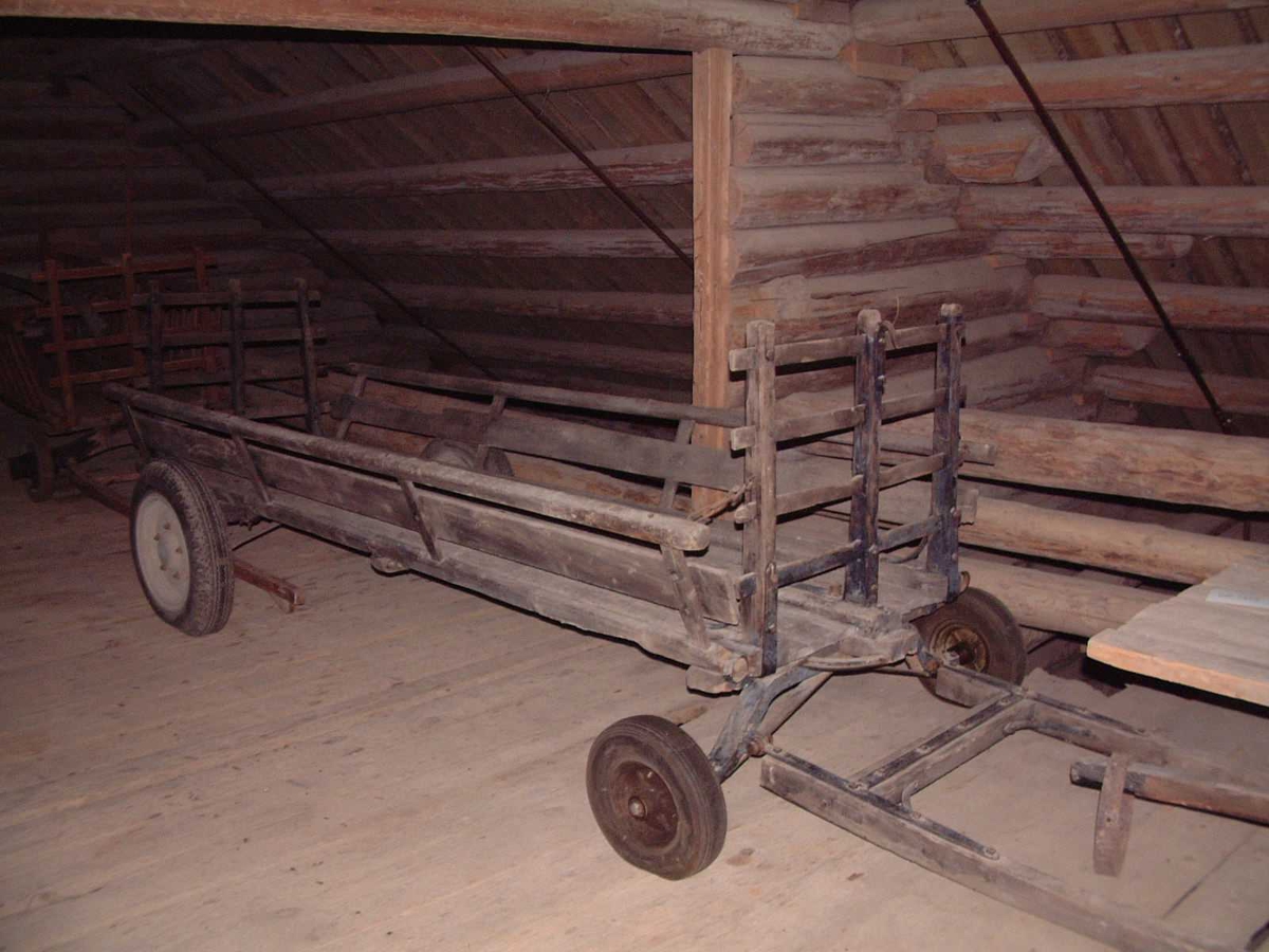 Forstilling bestående av jernaksel med svingflak. Bakaksel av jern. Lave hekker forbundet med kjettinger til framkar og bakkar. Fire gummihjul med slange og dekk. Draget er festet til framakselen med øyekroker, bolter og muttere. Delvis tjærebredd.