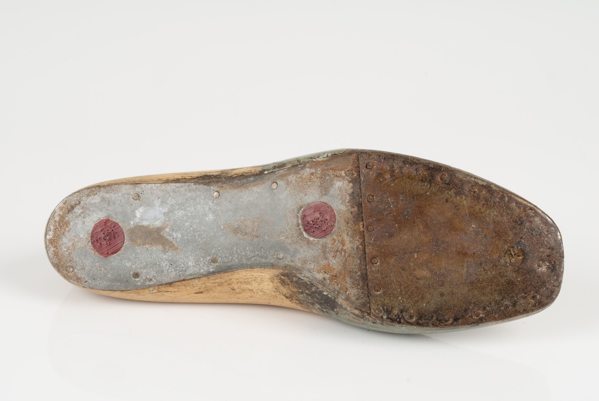 En tremodell i to deler; lest og opplest/overlest (kile).
Høyrefot i skostørrelse 41, og 8 cm i vidde.
Såle i metall.