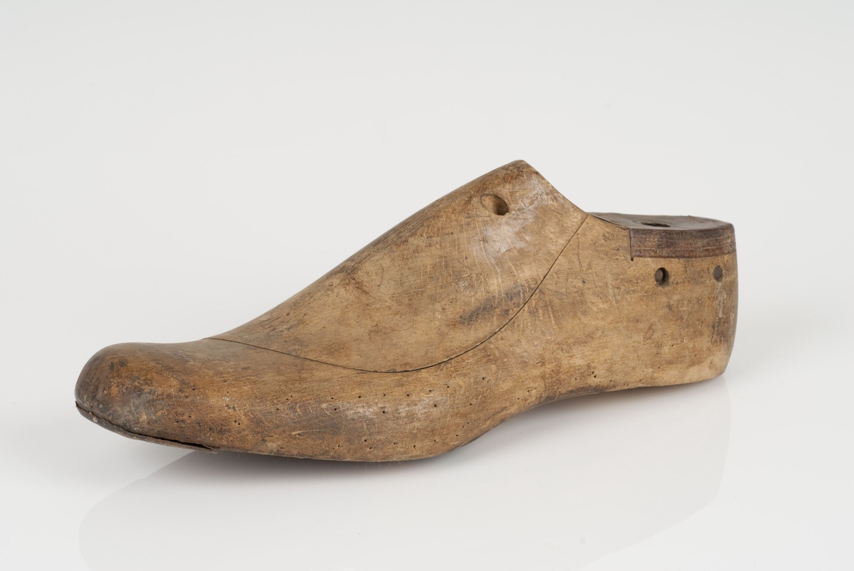 En tremodell i to deler; lest og opplest/overlest (kile).
Venstrefot i skostørrelse 47, og 8 cm i vidde.
Lestekam i skinn.
