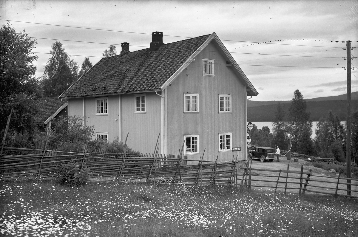 Drosjestasjon, bensinstasjon og landhandel. 1930-40 talls bilmodell utenfor.