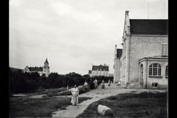 Bygning "Slottet", flere kvinner ( i lange kjoler) sees ute,