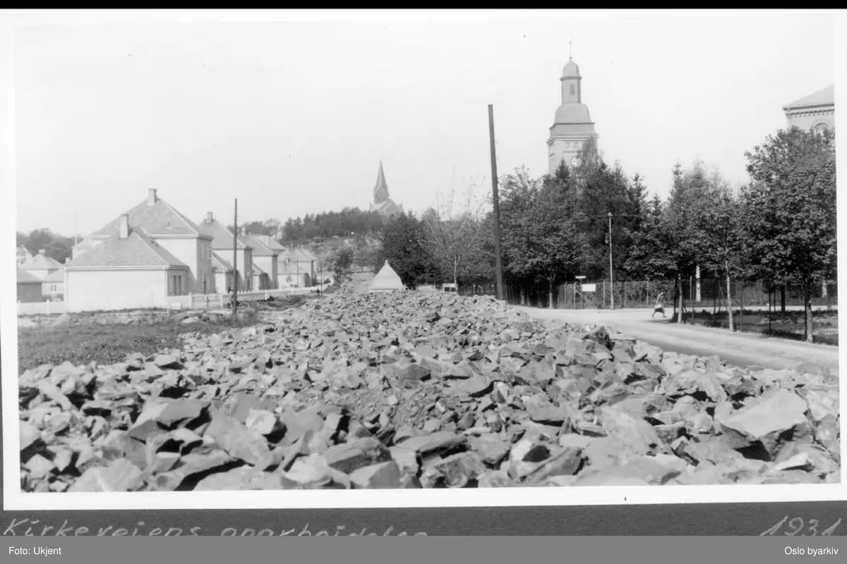 Opparbeidelse / Utvidelse av veien ved Ullevål sykehus. Kirkeveien 163 til 171 (nærmest) til venstre (Sagbankens stuer, kommunale aldershjem). Thulstrups gate opp til høyre. Sykehusets porttårn og Vestre Aker kirke i bakgrunnen. Allétrær.