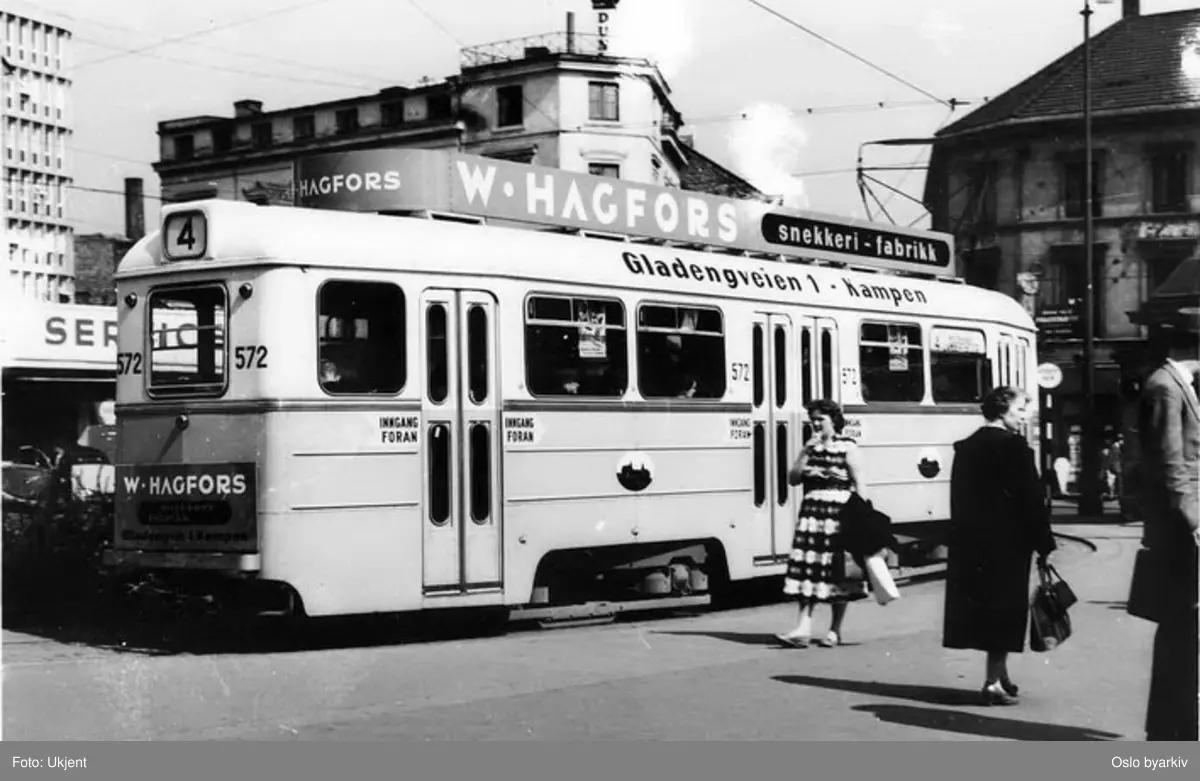 Oslo Sporveier. Trikk tilhenger 572 type TBO linje 4 til Bergkrystallen, her svingende inn i Vognmannsgata ved Jernbanetorget før Vaterlandsaneringen. Trikkereklame for W. Hagfors snekkerifabrikk, Gladengveien 1.