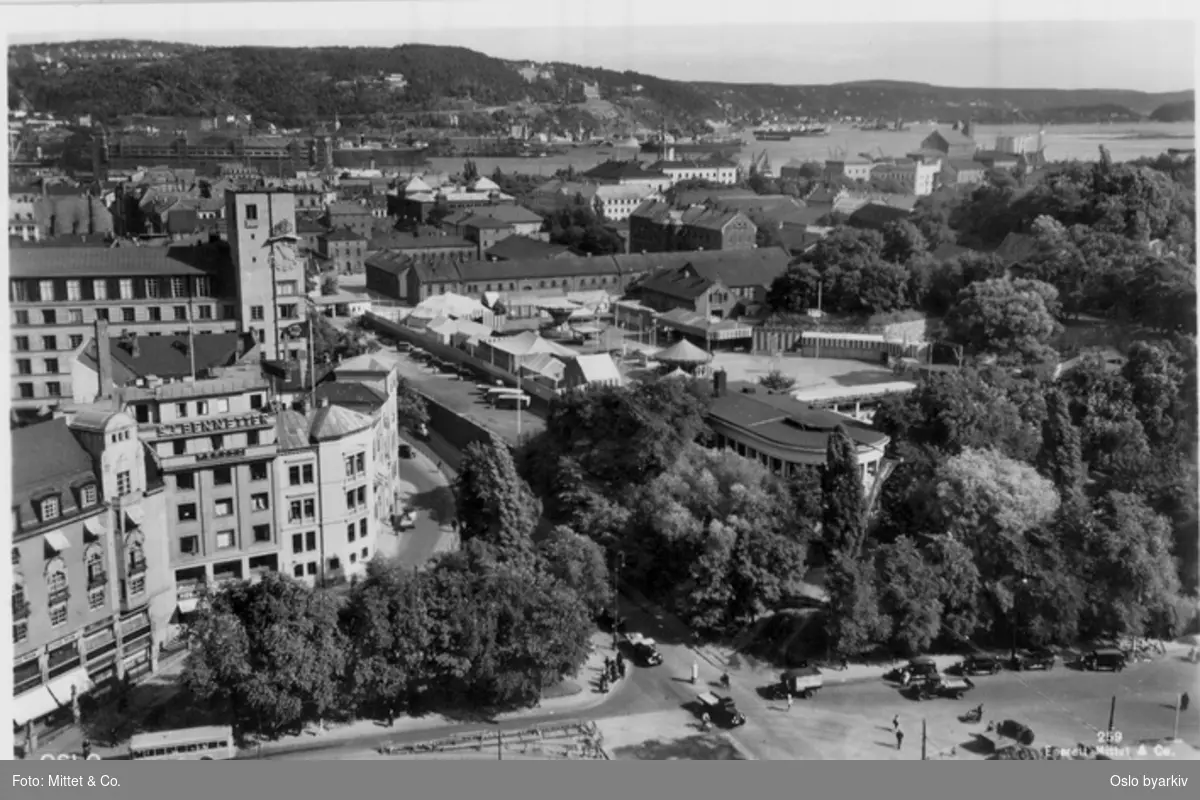 Utsikt mot Kontraskjæret, restaurant Skansen og Akershus festningsområde med tivoli (telt, karuseller m.m.). Rådhusgata, Tordenskiolds gate, Tordenskiolds plass. Postkort 259.