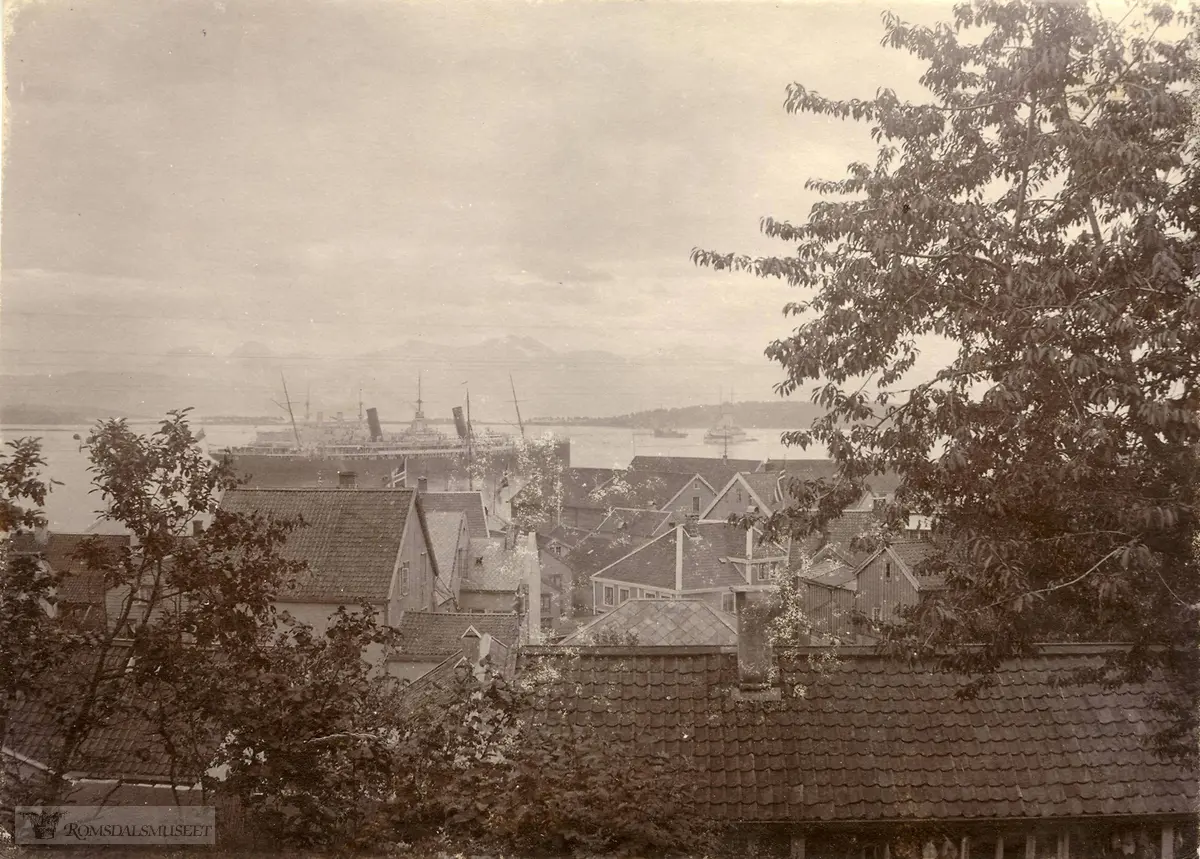 Skip på Moldefjorden..På fjorden, utenfor turistskipet, sees noen marinefartøyer. Et av dem kan gjenkjennes som et tysk slagskip av Wittelsbach-klassen, bygget i 1902 til 1904. Innen 1916 var samtlige av disse tatt ut av tjeneste. De norske flaggene på bildet er uten unionsmerke, så bildet må være tatt i perioden 1905 til 1914.