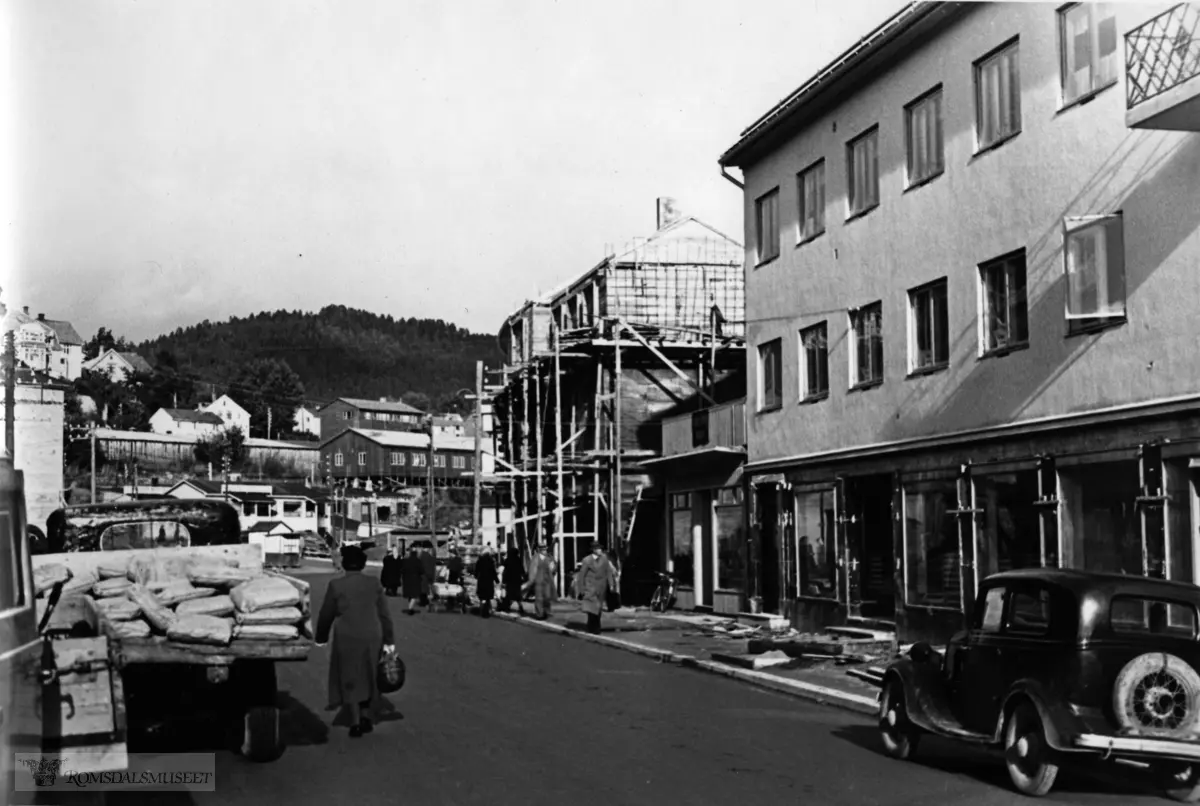 Gjenreising i Molde Storgata, 28 mot Torget..Bilen til høyre en Ford Junior (modell Y) fra 1934-37.