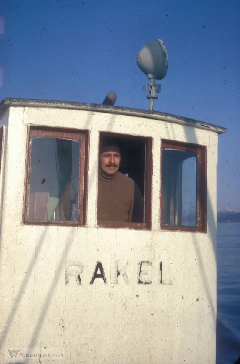 "Rakel".Malvin Frisnes i rorhuset på losskøyta Rakel (frå Teistklubben). I Romsdalsmuseets årbok 2009 side 199 står følgjande Bildetekst: " Stolt ny eier på vei over Hustadvika onsdag i påsken 1971." Rorhuset vart fjerna då Malvin restaurerte skøyta..(Se Romsdalsmuseets årbok 2009)