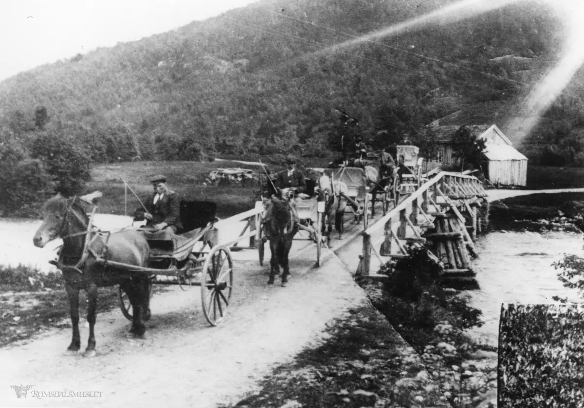 Hensbrua i Isfjorden før nybrua kom i 1913-14. .Karene har nok vært på Åndalsnes og skysset turister. Brustaua i bakgrunnen.