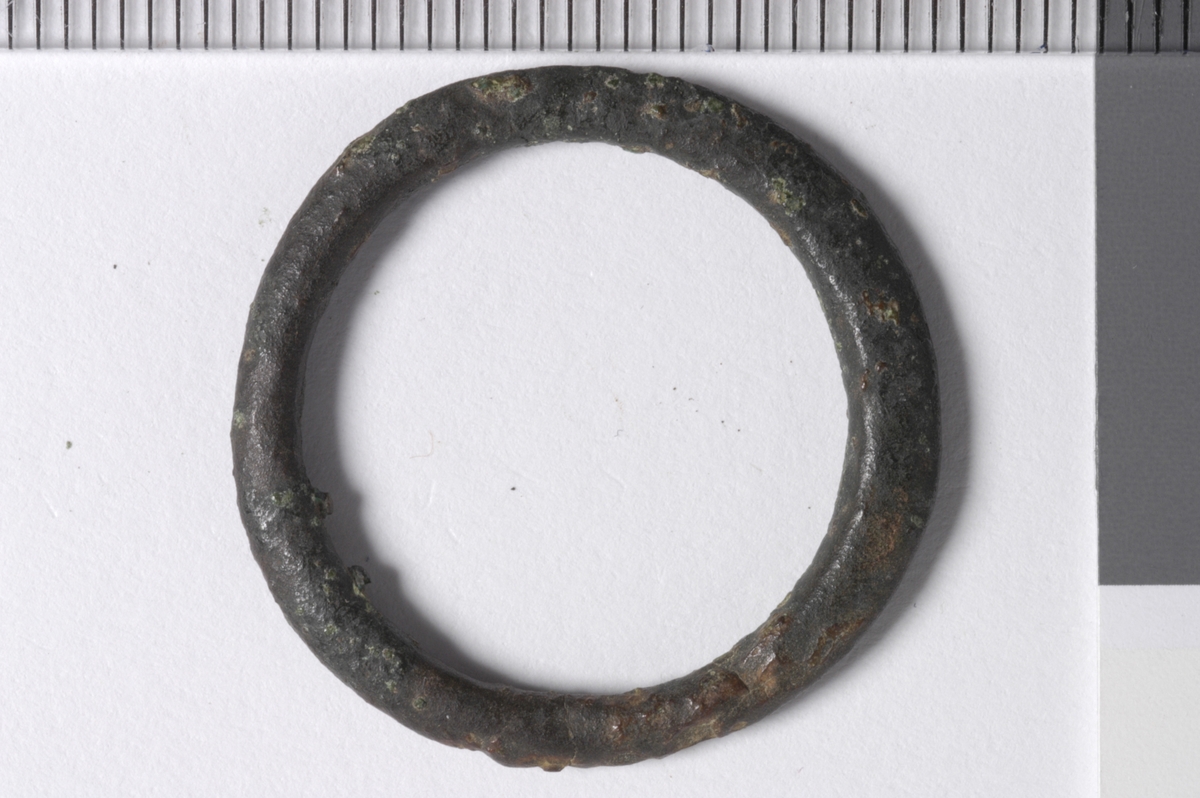 MALV: DIAM. 25  T. 3 MM, RINGFORMET, LAGET AV BÅND MED TILNÆRMET OVALT TVERR-SNITT. UTEN DEKOR. TORNEN MANGLER. SE PLATE LXXVII NR. 1 OG 2 - (MEDIEVAL CATALOGUE - LONDON MUSEUM 1967). 
