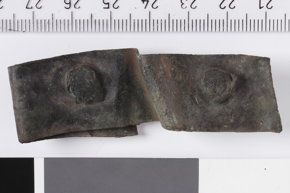 MÅL: L. 65 MM  B. 19 MM, LANG, REKTANGULÆR BRONSEPLATE MED TRE NAGLER PÅ PLASS. BØYD.