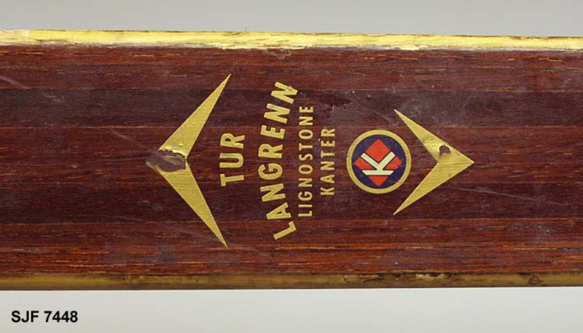 Enkelt turlangrennski uten binding. Skia er 208 centimeter lang. Bredden fremst, der kurven mot tuppen starter, er 5,9 centimeter. Ved bindingsstedet er bredden 4,9 centimeter. Bakerst er bredden 5,5 centimeter. Skia er med andre ord noe innsvingt (konkav) i lengderetningen. Tjukkelsen der hvor kurven mot tuppen starter er 0,6 centimeter. På midten, der hvor bindinga skulle monteres, er tjukkelsen 2,5 centimeter. I den bakre enden, som er noe oppsvingt, er tjukkelsen om lag 0,7 centimeter, cirka 5 centimeter framfor endebeslaget. Langs midtaksen på undersida (sålen) er det høvlet ei styrerand, en cirka 1,0 centimeter bred hulkil. Langsmed sålens ytterkanter har skia 6-7 millimeter brede hardvedkanter, lagd av lignostone, bøkeved som er presset under høyt trykk, og som her framstår som mørkere enn det øvrige treverket i skiene. Oversida av skia er brunlakkert, med unntak av smale faser langs sidekantene, Giveren mener at dette er ei «Toppen-ski» fra Gjøvik skifabrikk, men et klistremerke med en innringet «K» kan peke i andre retninger. Bakskiene er merket med et klistremerke der det står «MADE IN NORWAY». Framfor bindingsfestet er sifrene «210» (skilengden) og «2563» (muligens et priduksjonsnummer) innstemplet.