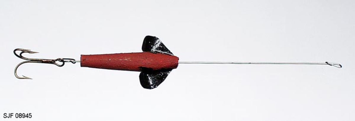 Sluk, devonsluk, av tre. Sluken er hjemmelaget med hull gjennom hele kroppen. Det er ant. en devonsluk. Den er blitt brukt til otring etter abbor. Den ble laget i tre for at den skulle gå i vannskorpa. Sluken har 1 stk. treblekrok. Kroken, treblekroken (trippelkroken), er festet til en metallstang. Metallstanga er ført gjennom den fiskeliknende kroppen. Foran, på sidene av "hodet", er det pålimt vinger (propellvinger), slik at sluken roterer (spinner) rundt sin egen akse. Propellvingene er laget av tynne metallplater. Sluken er bemalt med sølvfarge, rødbrunt og svart.