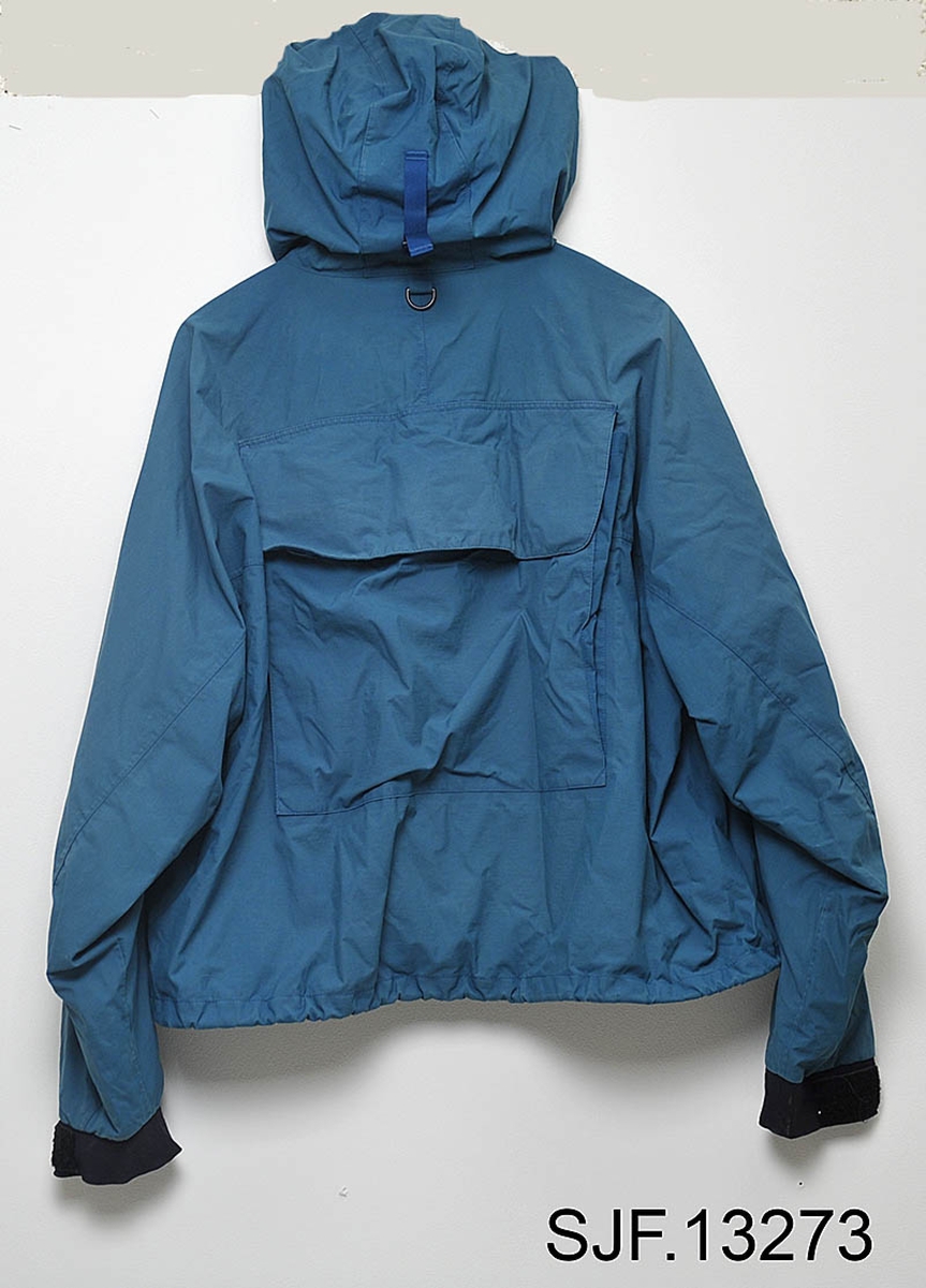 Jakka er produsert av firmaet Patagonia, en meget anerkjent produsent av kvalitetsklær beregnet på fluefiskere. Den er blåfarget i størrelse XXL. 

Den er i Goretex, noe som gjør den behagelig å ha på seg på varme sommerdager og holder fiskeren tørr når det regner. Jakka er forsynt med fast hette som kan justeres med strikk på innersiden mot ansiktet og ei rem i nakken. 

Jakka har 2 ganske store brystlommer for oppbevaring av fluebokser eller lignende. I den venstre innerlomma er det ei lita lomme som kan stenges med en glidelås. På innsiden av den venstre delen av jakka er det også si lita lomme som kan lukkes med glidelås. På ryggen er det ei stor lomme beregnet på store ting som for eksempel ekstra klær. Øverst på ryggen er det en liten d-ring for å feste hoven på. På fronten av jakka er det to d-ringer beregnet på å feste krokløser, fortomsklipper, og lignende. Øverst på venstre frontdel er det en borrelås beregnet på å holde fluestanga på plass mens man for eksempel skifter flue. Bunndelen av stanga settes i ei lita hempe som befinner seg nederst på innsiden av høyre jakkedel. Jakka kan lukkes med glidelås og borrelås. Mot halsen er det ei 13 cm. lang vattert klaff slik at glidelåsen ikke skal komme i kontakt med huden på halsen. Jakka kan justeres med en strikk nederst. Mot håndleddene er det borrelåsjustering som kan strammes rundt håndleddet for å holde regnvann ute når man kaster med flue. Jakka er forsynt med et innerfor i et mykt netting-stoff. 

Jakka er en såkalt lang vadejakke beregnet på å brukes sammen med vaderbukser som går opp til brystet. 

Jakka ble kjøpt av OT. Ljøstad i den lille byen West Yellowstone i Montana, USA, for 15 – 20 år siden. 