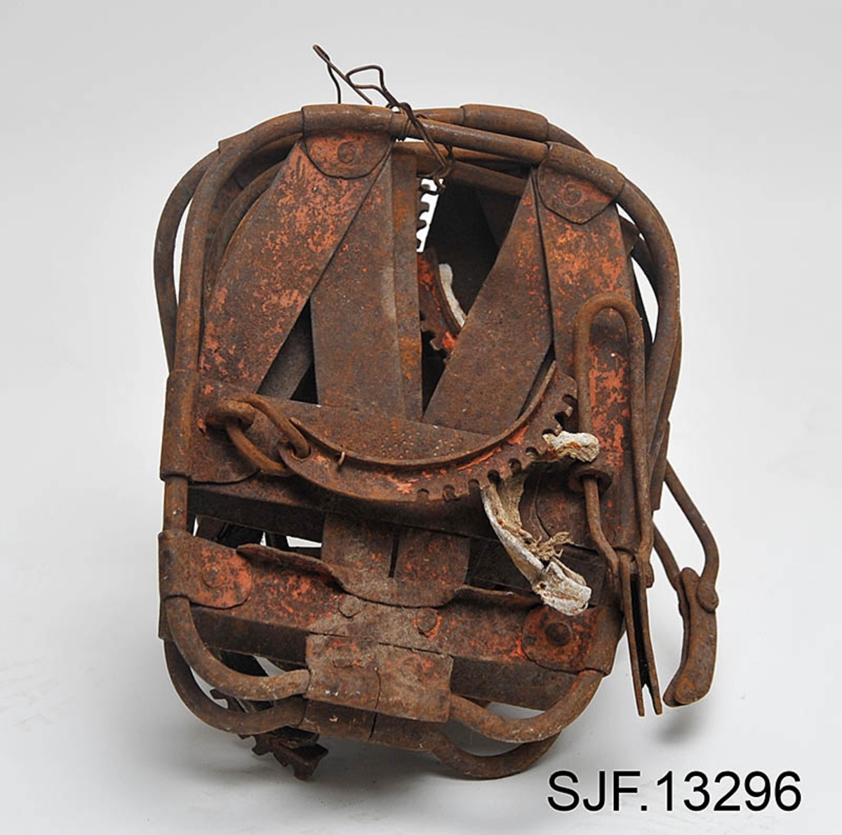 Trugesett for hest, altså fire stykker.  Trugene er lagd av jern.  Rammene er lagd av rør med cirka 1,1 centimeters diameter.  Disse rørene er bøyd i tilnærmet rektangulær form, men med noen avrundete hjørner.  Hver truge er om lag 30 centimeter lang og 24,5 centimeter bred, og har dermed ei bæreflate på drøyt 700 kvadratcentimeter.  Formen holdes stabil ved hjelp av jernband som er bøyd rundt rammerørene og klinket sammen.  To slike band går på tvers av trugene (i bredderetningen) mens det i lengderetningen er lagt band i M- eller W-mønster (avhengig av hvilken veg trugene holdes, M hvis de betraktes skrått bakfra).  De bakerste tverrbandene har kanter som er bøyd oppover, antakelig for å kunne tjene som anlegg for hakene på skogshestens vintersko.  Gjennom de brede tverrbandene noe lengre fram på trugene er det ført jernører med gjennombrutte hull for hengslingslekker for bøyler som ble lagt over hornveggene på hestens framføtter. Den ene bøylehalvdelen har T-formet tverrsnitt med hakk i overkant og lærfôringer på undersida (festet med ståltråd). Ei truge mangler slik fôring, de andre er stive og sprø etter mange års tørk uten tilførsel av nye fettstoffer. Den andre halvdelen av bøylemekanismen består av en lang, buet kjettinglekk med ei dreibar klype med ei gjennomgående nagle like bak hengslingspunktet. Denne nagla føres ned i ett av hakkene på ryggen av den andre bøylehalvdelen, hvoretter endeleddet presses ned. Dermed låses truga godt til foten på hesten. Under tverrbandene bøylene er festet i er det montert jernstag med T-formet tverrsnitt på tvers av trugenes lengderetning. Disse komponentene skulle antakelig redusere faren for at trugene skled på vinterføre. De nevnte tverrstagene er for øvrig festet med kvadratiske muttere på endetappene av «jernørene» som bøylene på oversida av trugene er hengslet til.  På jernet kan vi se spor av oransje lakk, men fargestoffet er i ferd med å bli fortrengt av gravrust. Trugetypen later til å være en serieprodusert artikkel. De brede tverrbandene på to av trugene er merket «ØR» i prikket utførelse. Trugesettet ble levert til museet sammenbuntet med en ståltråd, antakelig slik de har vært oppbevart siden sist de var i bruk.  Ifølge siste eier, Magne Ottershagen fra Styggberget i Elverum, skal dette ha vært vinteren 1953-54.

I Sverige kalles denne trugetypen «norsktrampa», hvilket vel indikerer at det må ha vært en norsk produsent som har eksportert slike truger til nabolandet.