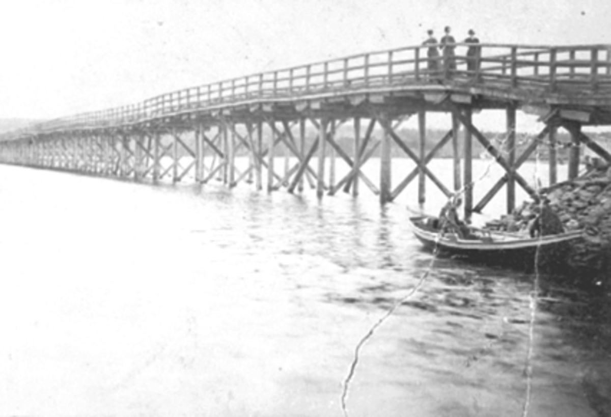 Hamar, Åkersvika, Stangebrua, første bro bygd i 1868/69, ombygd i 1891, i 1930 kom steinfyllinga, 3 damer på broen, robåt i forgrunnen, 

