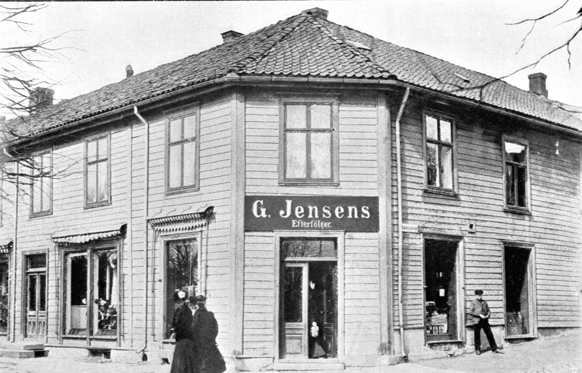 Hamar, Simensgården, Strandgata 71 i krysset Strandgata / Bekkegata. Forretningen til G. Jensens eftf (H. Lund?), folk utenfor. bygården ble satt opp i 1850 og brant ned i 1946.