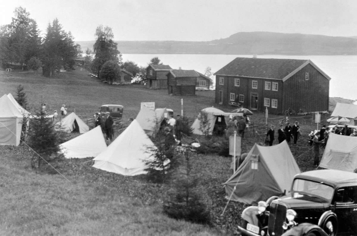 K. N. A. CAMPING-UTSTILLING MED TELT, BILER OG MYE FOLK FORAN LØTENBYGNING. HEDMARKSMUSEET OG DOMKIRKEODDEN. Nærmeste bil: Chevrolet 1933.
