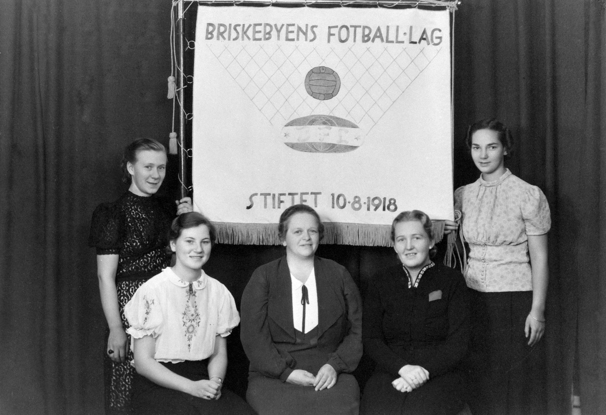 Hamar, Briskebyens fotballag stiftet 10. august 1918, damegruppen (1938-1946) med formann Aslaug Finstad, med ny fane overlevert ved 20 års jubileet ved en kamp mellom HIL og  BFL, fargene hvitt og grønt for draktene ble valgt i 1931,  Fra venstre: Ingeborg (Sjølie) Taskerud, nestformann Edel Rosenlund g. Rasen, kasserer Agnes Hauglie, formann Aslaug Finstad g. Berg, sekretær Synnøve Jachwitz g. Bekkevold,