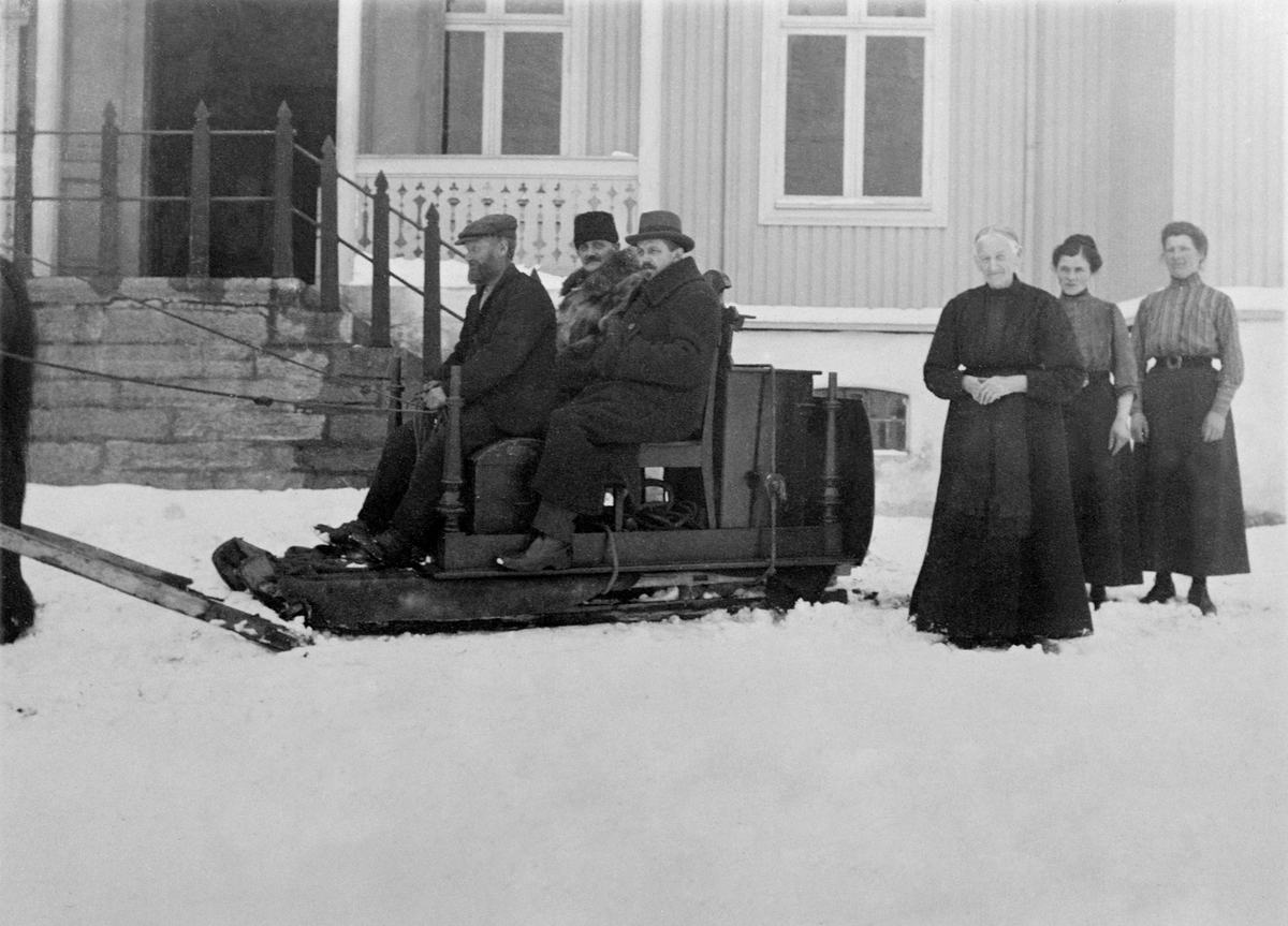 Ringsaker, Tingvang, Hest med slede og flyttelass. Johannes Staf kjører sleden. J. Røhr og Halvdan Skappel f.1876 på sleden. De tre damene er Eli Skappel f.1849, Marie Kristiansen f.1895, Agnethe Evenstad f.1880. Ringsaker Sparebank flytter fra Tingvang til Moelv.