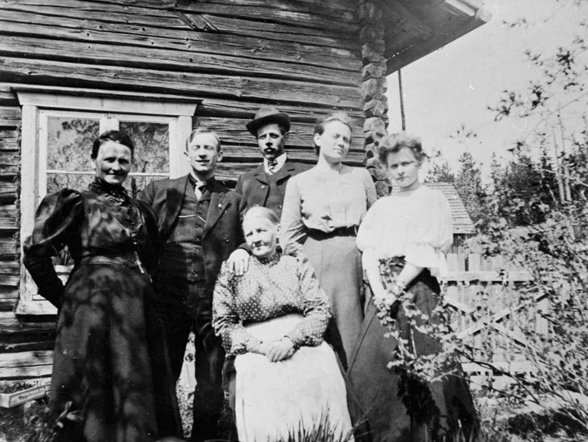 Øvre Maurud(Nordre) på Helgøya. Foran sitter Elisabeth Larsdatter Maurud (1839-1930) hun var gift med snekker Paul Larsen Maurud (1838-1896) som kjøpte Maurud i 1882. Bak fra venstre Lovise Larsdtr Johannessen søster til Paul Maurud. Så er det Lovises sønn Johs Johannessen,så står Elisabeth sine to barn Ole Paulsen Maurud med hatt og Lydia Paulsdtr Maurud. Til høyre står Anna Marie Johannessen som er Louises sin datter.