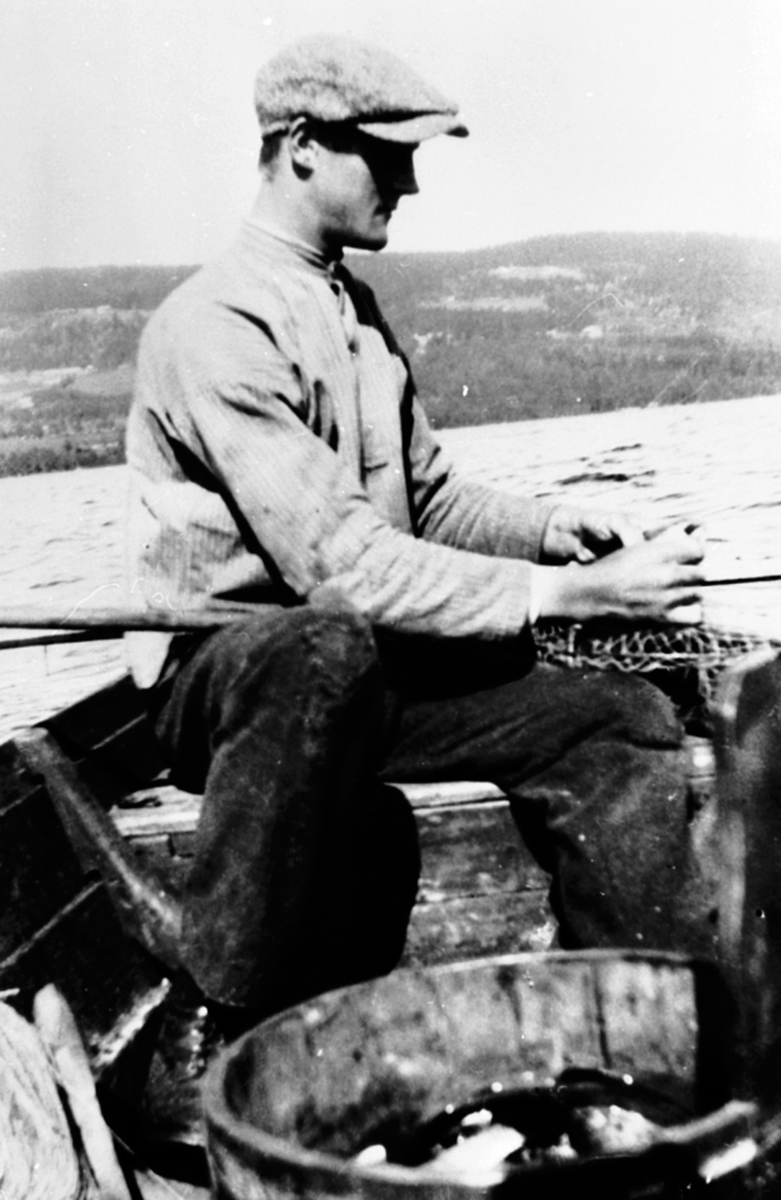 Thor Solbakken f.1903 fisker med reiv fra robåt på Sørmesna, Ringsaker.