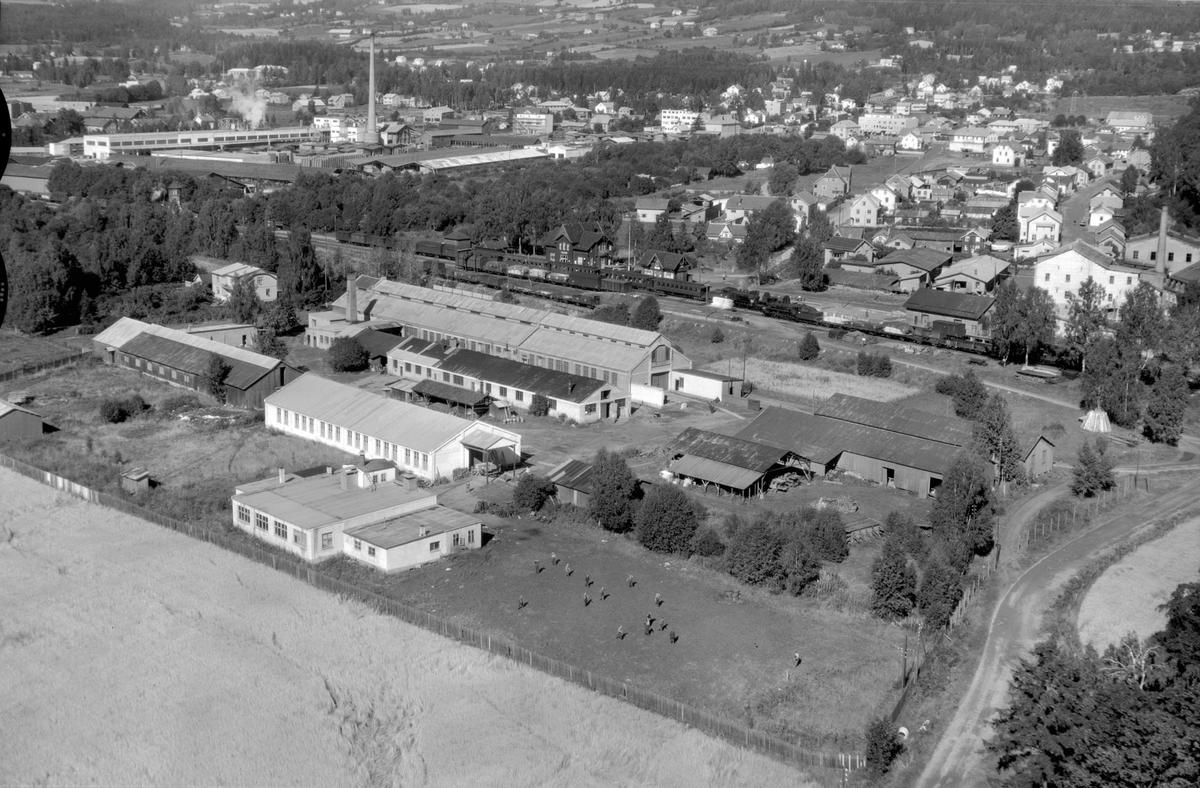 Flyfoto av Brumunddal stasjon, Globus Maskinfabrikk, bebyggelsen i Brumunddal sentrum.