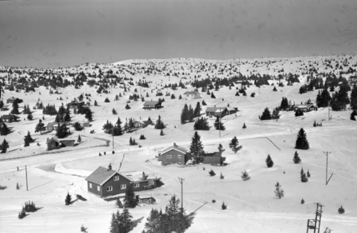 Flyfoto av bebyggelse i vinterlandskap på Sjusjøen, Ringsaker Almenning.