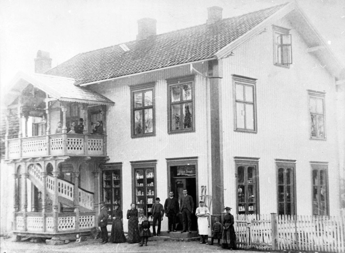 Eksteriør, Øverenga, brødrene Jevanord landhandel, etter 1917, Thingelstadgården, fra venstre er Hans Jevanord, Oline Jevanord, Karen Jevanord (goft Kristiansen), 2 barn, Petter Olai Jevanord, baker Sandberg. På veranda er Johannes og Gina Jevanord, ukjente batn. Gamlegata, Brumunddal.