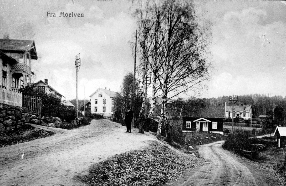 Postkort, Oversikt, Åsmarkavegen , Moelv ,med boliger, mann i vegen.